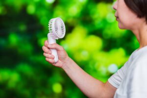 woman going through menopause has a fan in her hands