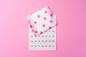 A picture of a menstrual pad and a calendar with marked dates to help identify menstrual irregularities